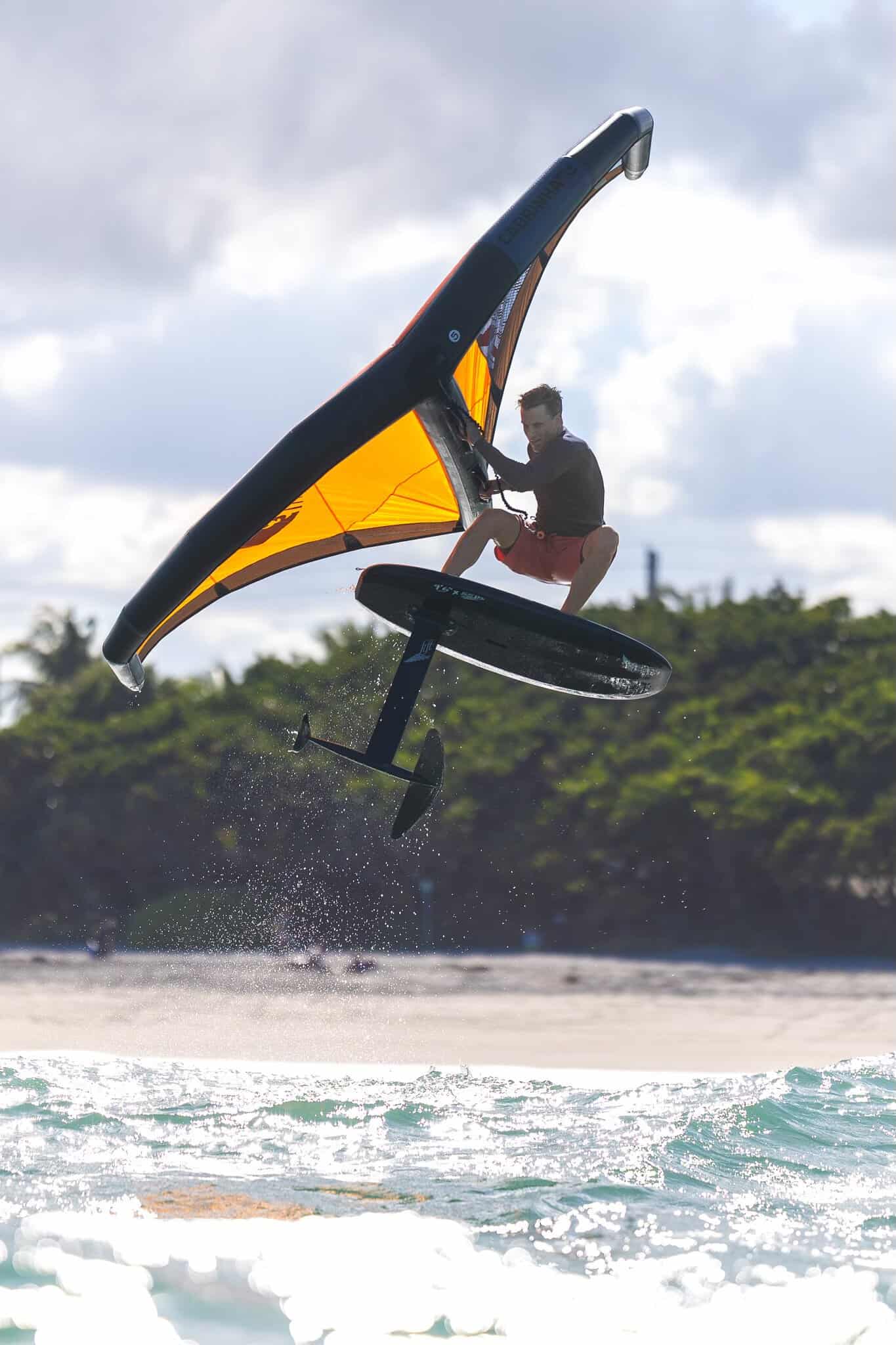 Vélo électrique surfant au-dessus de l'eau avec une ailes de kite en pleine action, technologie de foil pour sports nautiques, option de loisir aquatique innovante, pratique pour la glisse sur mer ou lac.
