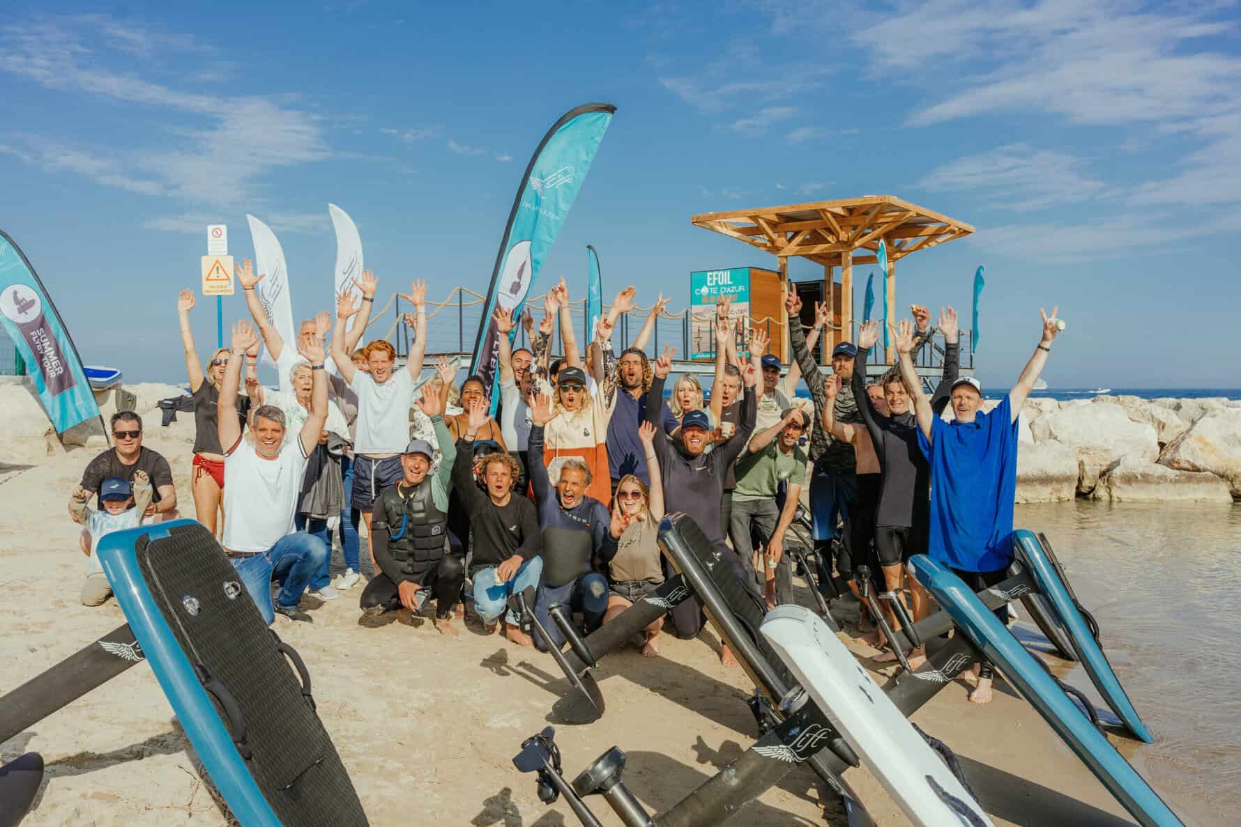 Innovateurs en sports nautiques, groupe de passionnés de foil électrique sur la plage en France, célébrant le lancement de leurs nouvelles planches Lift Foil.