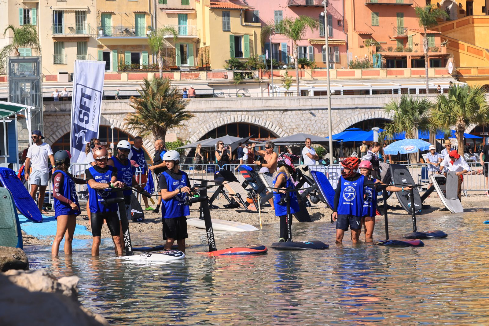 Riders au départ dans l'eau, vieille ville de Menton derrière