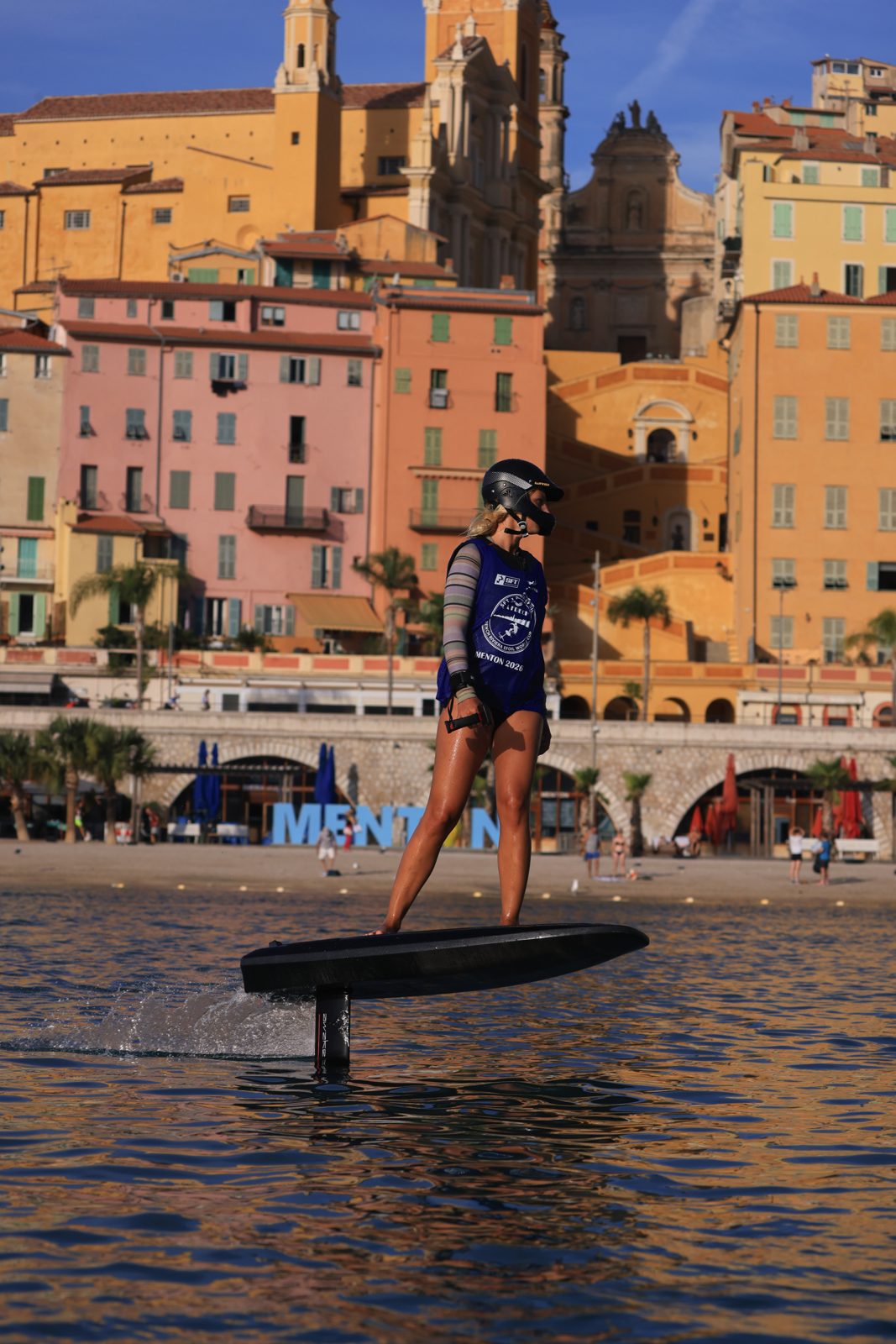 Rider eFoil devant les façades ocre de la vieille ville de Menton, finale SFT 2026